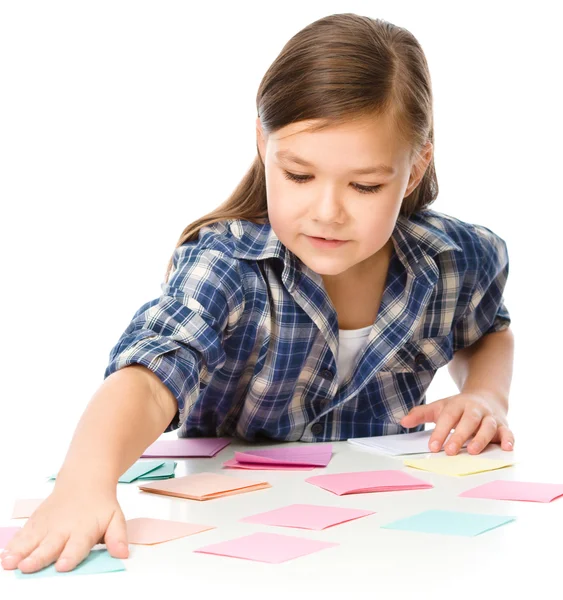 Girl is writing on color stickers using pen — Stock Photo, Image