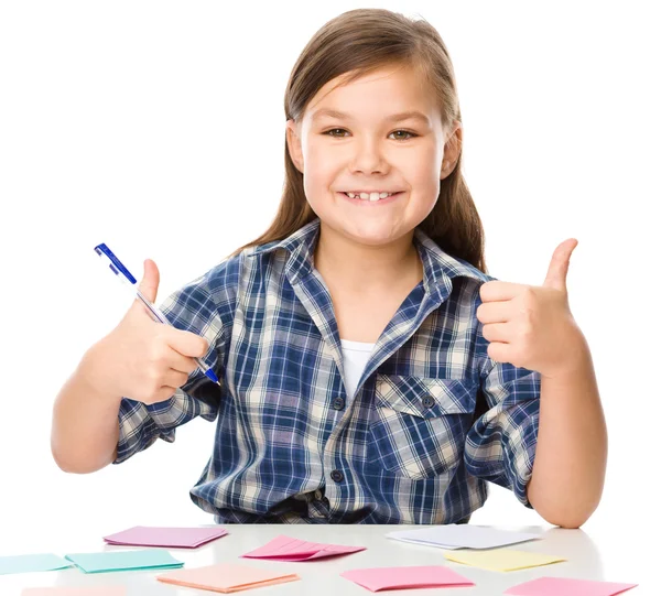 Ragazza sta scrivendo su adesivi a colori utilizzando penna — Foto Stock