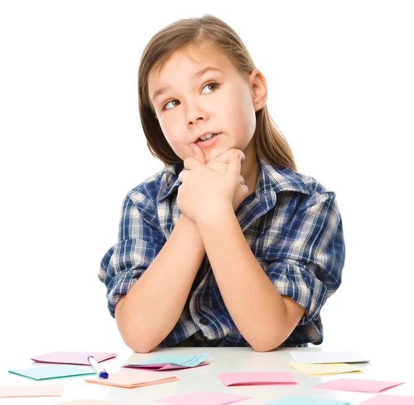 Ragazza sta scrivendo su adesivi a colori utilizzando penna — Foto Stock