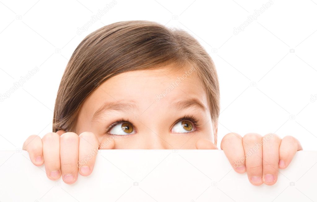 Little girl is looking from out blank board