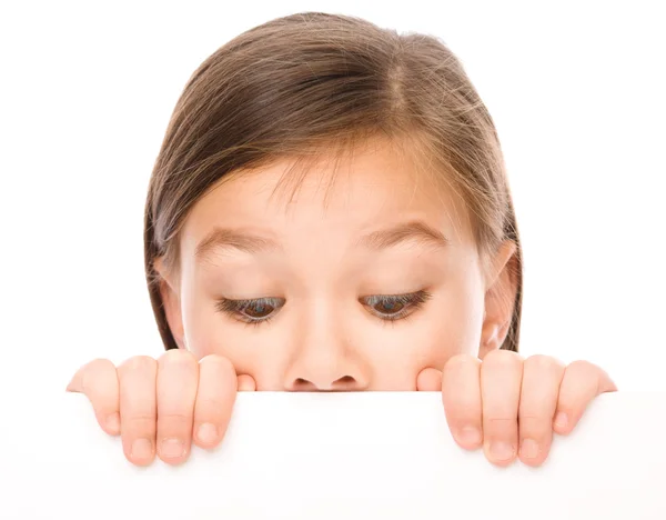 Niña está mirando desde el tablero en blanco — Foto de Stock