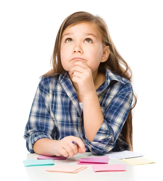 Girl is writing on color stickers using pen — Stock Photo, Image
