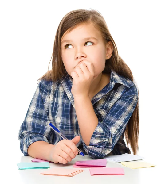 Girl is writing on color stickers using pen — Stock Photo, Image