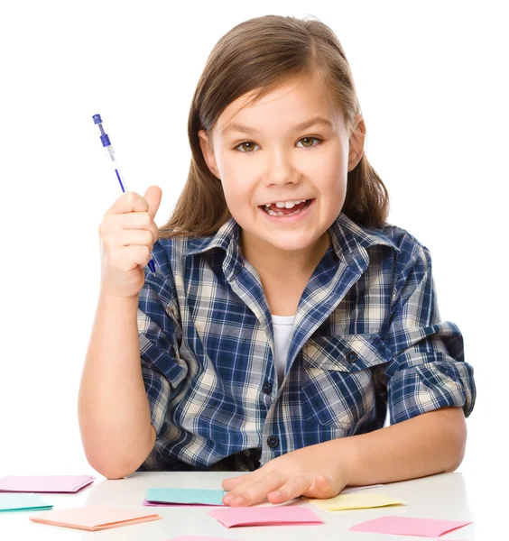 Girl is writing on color stickers using pen — Stock Photo, Image