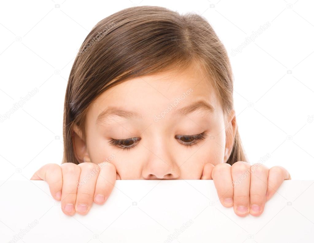 Little girl is looking from out blank board