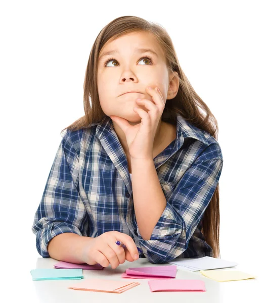 Girl is writing on color stickers using pen — Stock Photo, Image