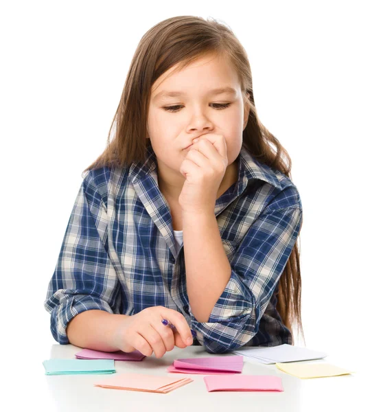 Dziewczyna jest pisanie na kolor naklejki za pomocą pióra — Zdjęcie stockowe