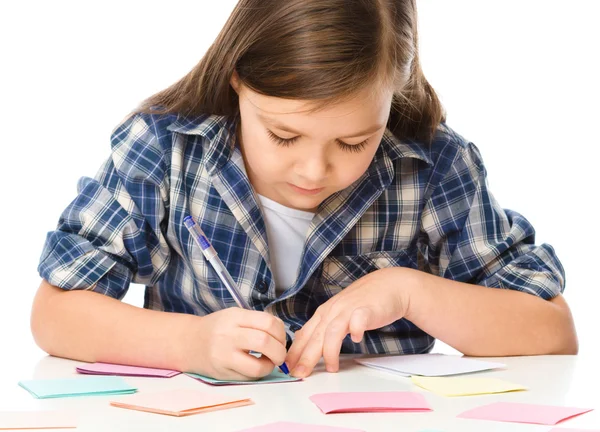 Meisje is het schrijven op kleur stickers met pen — Stockfoto