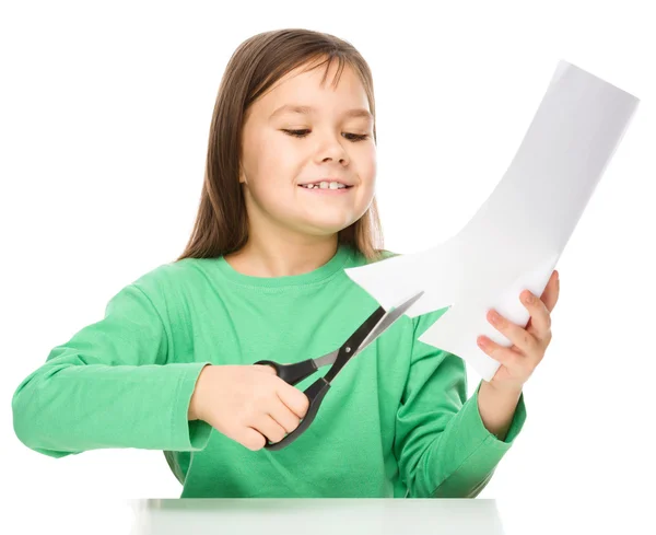 Ragazzina sta tagliando la carta con le forbici — Foto Stock