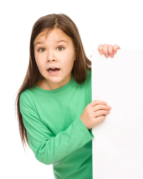 A menina está olhando para fora do banner em branco — Fotografia de Stock