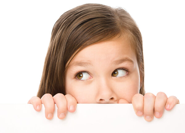 Little girl is looking from out blank board