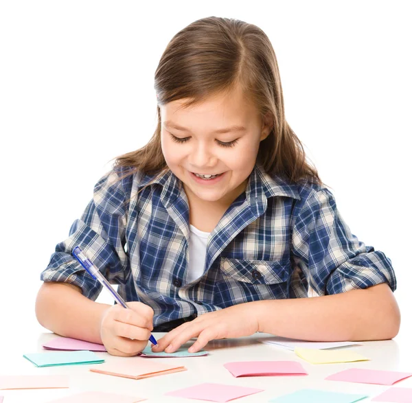 Ragazza sta scrivendo su adesivi a colori utilizzando penna — Foto Stock