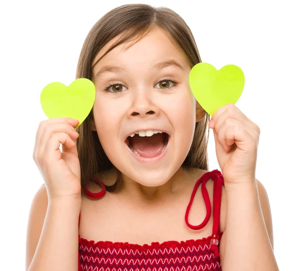 Little girl is holding hearts near her eyes — Stock Photo, Image