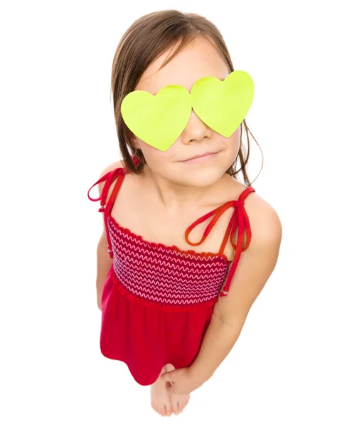 Little girl is holding hearts over her eyes — Stock Photo, Image