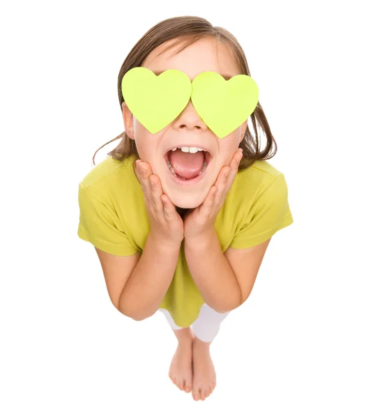 Little girl is holding hearts over her eyes — Stock Photo, Image