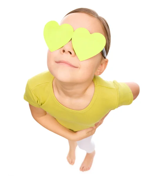 Little girl is holding hearts over her eyes — Stock Photo, Image