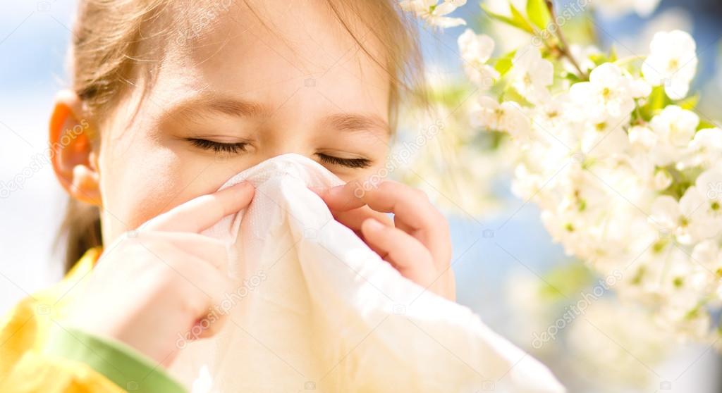 Little girl is blowing her nose