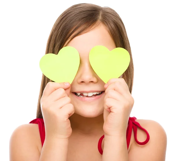 Little girl is holding hearts over her eyes — Stock Photo, Image