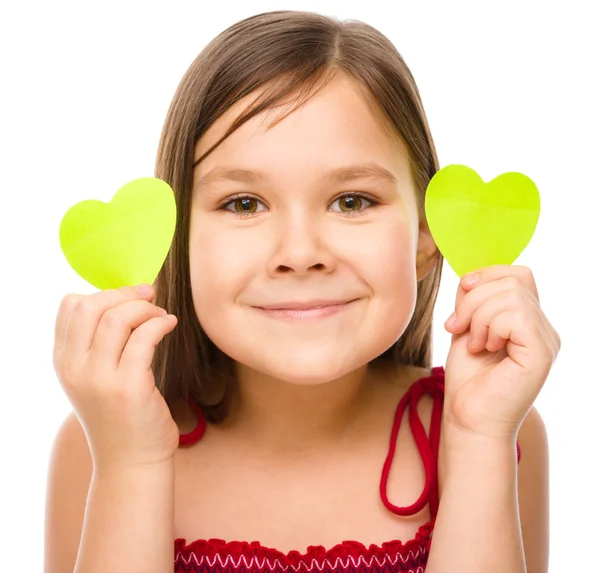 Little girl is holding hearts near her eyes — Stock Photo, Image