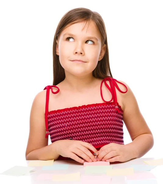 Ragazza sta scrivendo su adesivi a colori utilizzando penna — Foto Stock