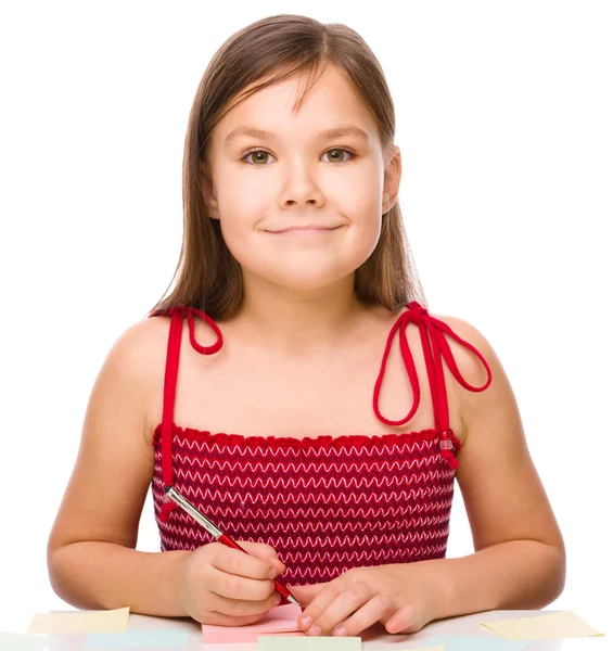 Mädchen schreibt mit Stift auf Farbaufkleber — Stockfoto