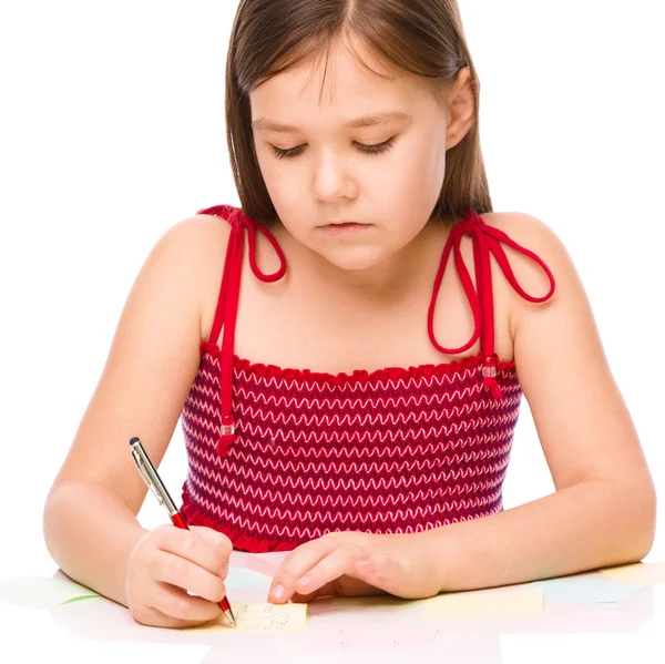 Chica está escribiendo en pegatinas de color usando pluma —  Fotos de Stock