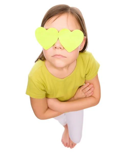 Little girl is holding hearts over her eyes — Stock Photo, Image