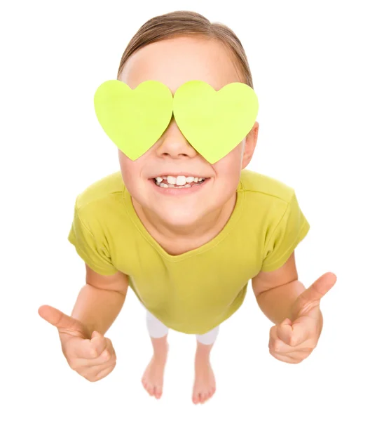 Niña sostiene corazones sobre sus ojos — Foto de Stock