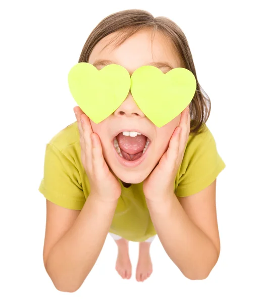 Little girl is holding hearts over her eyes — Stock Photo, Image