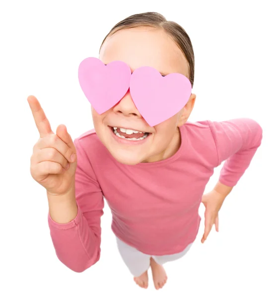 Little girl is holding hearts over her eyes — Stock Photo, Image