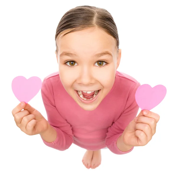 Little girl is holding hearts near her eyes — Stock Photo, Image