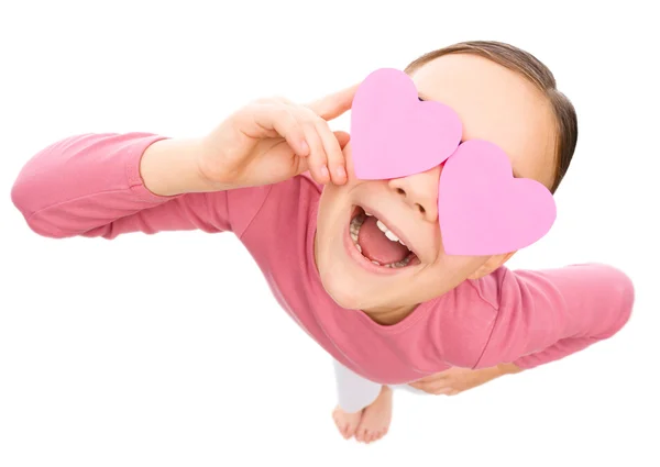 Little girl is holding hearts over her eyes — Stock Photo, Image