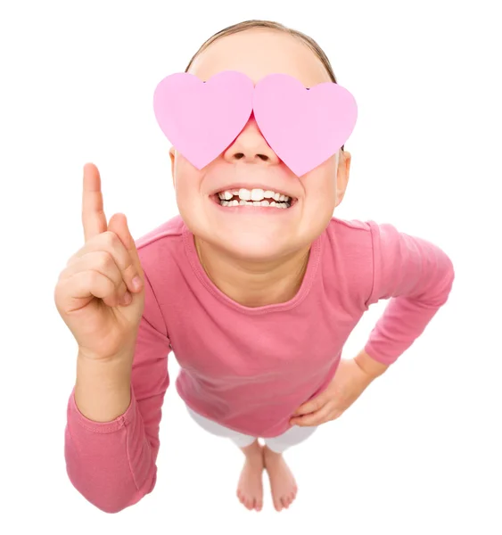 Little girl is holding hearts over her eyes — Stock Photo, Image