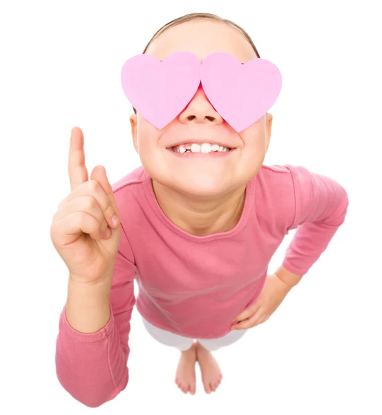 Маленька дівчинка тримає серця над очима — стокове фото