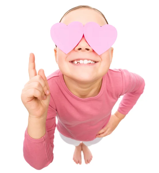 Little girl is holding hearts over her eyes — Stock Photo, Image