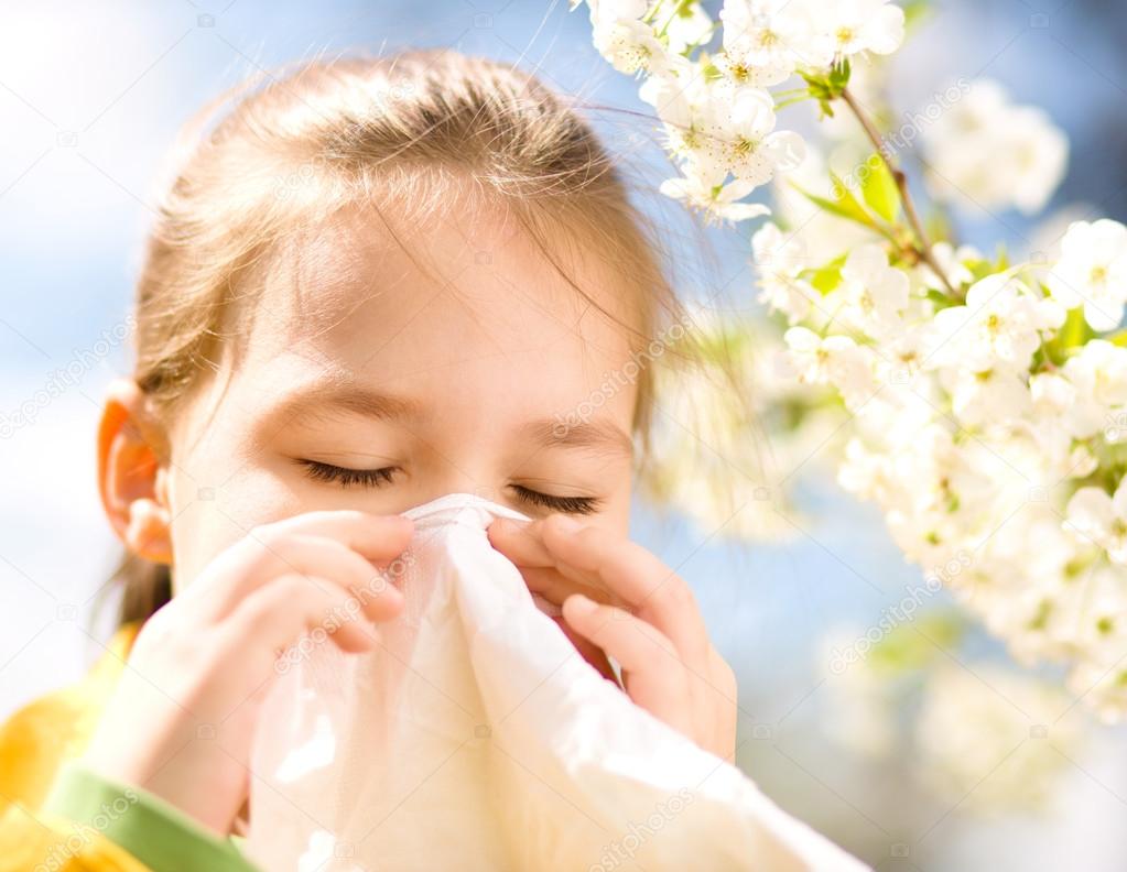 Little girl is blowing her nose