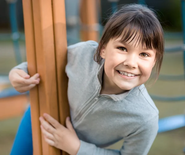 Linda niña está jugando en el patio de recreo — Foto de Stock