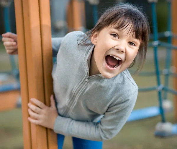 Cute dziewczynka bawi się w plac zabaw dla dzieci — Zdjęcie stockowe