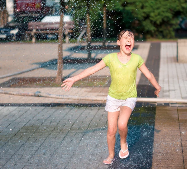 Mädchen läuft durch Springbrunnen — Stockfoto