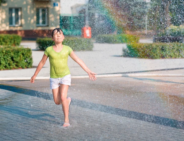 女の子は噴水を通じて実行されます。 — ストック写真