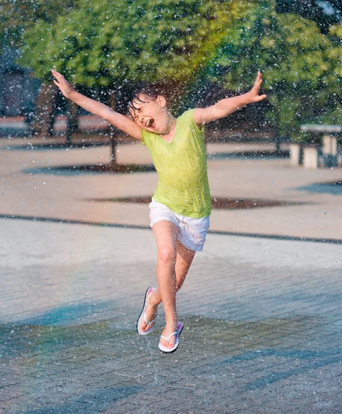 Mädchen läuft durch Springbrunnen — Stockfoto