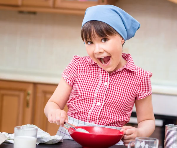 Chica está cocinando en la cocina Imágenes de stock libres de derechos