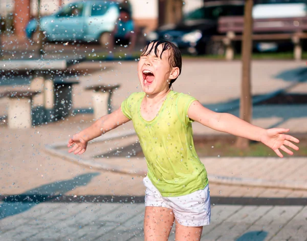 Mädchen läuft durch Springbrunnen — Stockfoto