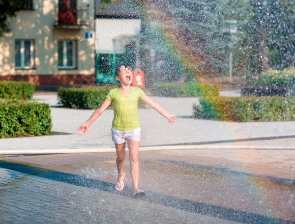 女の子は噴水を通じて実行されます。 — ストック写真