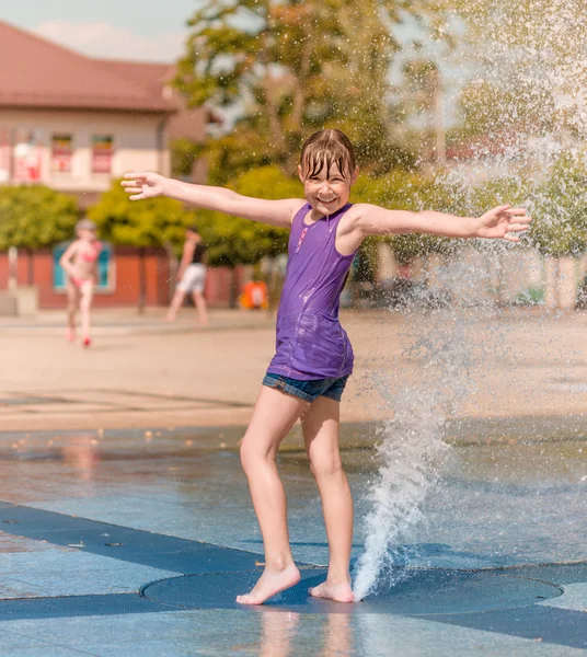 Девушка наслаждается фонтаном с холодной водой — стоковое фото