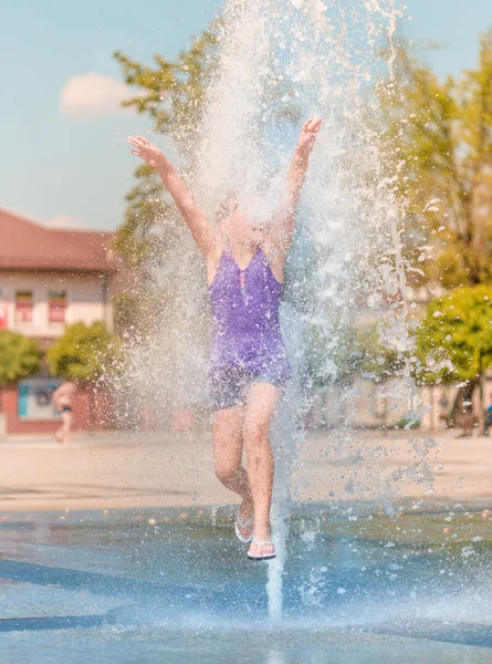 少女は冷たい水の噴水を楽しんでいます。 — ストック写真