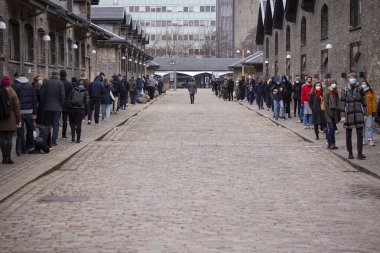 Coronavirus Covid-19 testleri için sırada bekleyen insanlar şehir test merkezinde sosyal mesafeyi test ediyorlar. Kopenhag, Danimarka - 21 Aralık 2020.