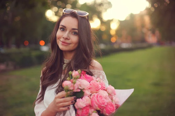 Menina bonita nova com rosas rosa — Fotografia de Stock