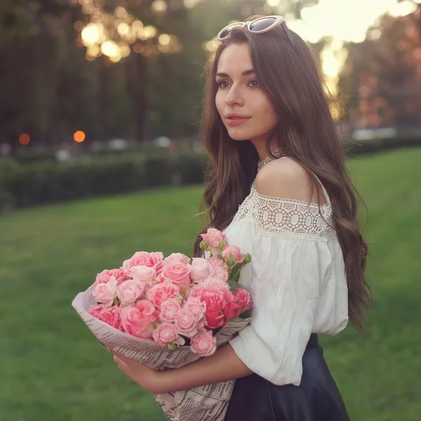 Ung vacker flicka med rosa rosor — Stockfoto