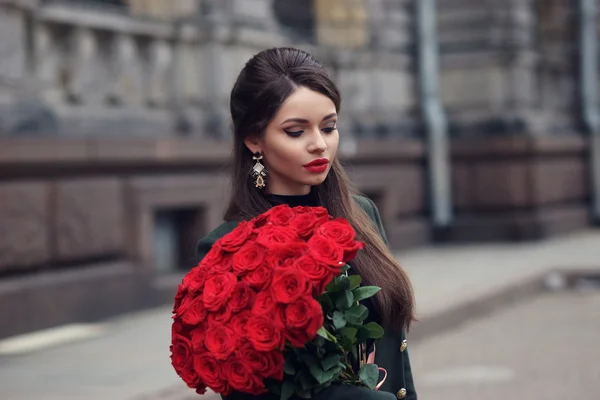 Frau mit Strauß roter Rosen — Stockfoto